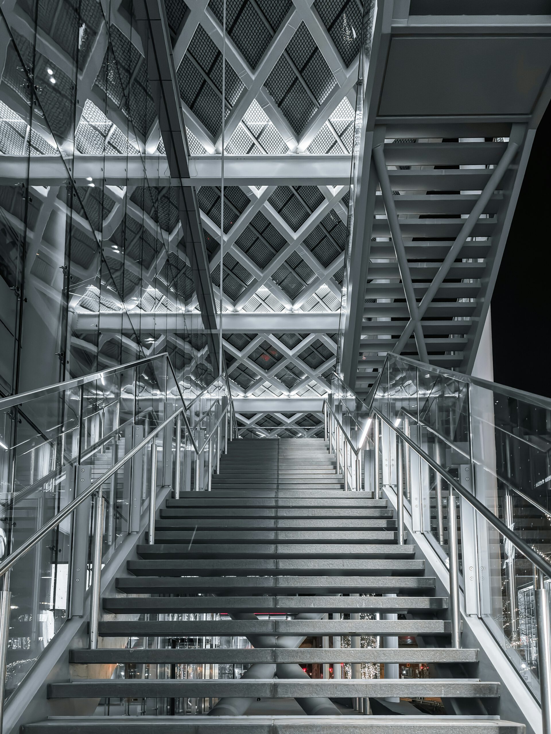 Innenansicht einer Stahl-Glas-Konstruktion mit Treppenanlage und Fachwerkträgern